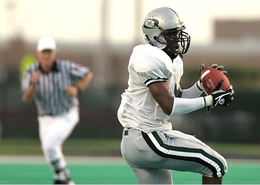 A football player in a defensive stance, ready to tackle.